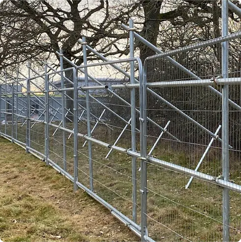 A metal security fence with wire mesh panels